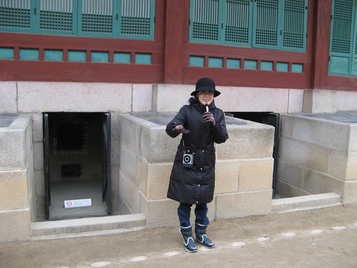 South Korea: Seoul, Changdeokgung Palace: Guide Explaining under-floor heating oven