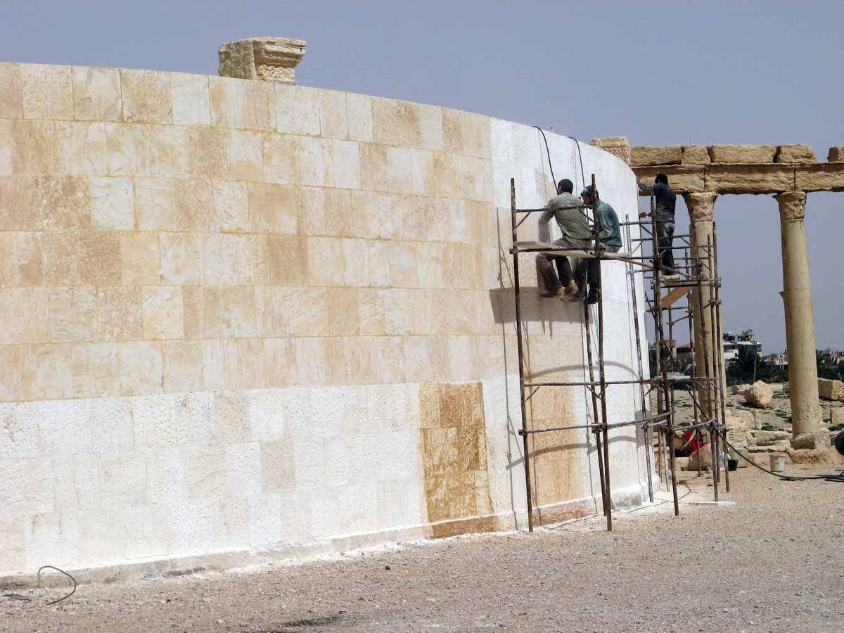 Palmyra, New outer wall for Theatre Workmen are using tools to "age" new stone.