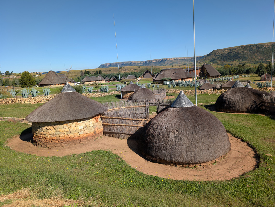 Lesotho: Thaba Bosiu tour, Traditional houses Older style on right, later style on left.